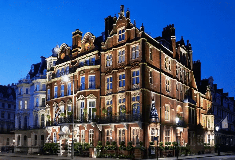 Exterior of Milestone Hotel in London at night, surrounded by bright street lamps, with a luxurious and welcoming appearance.
