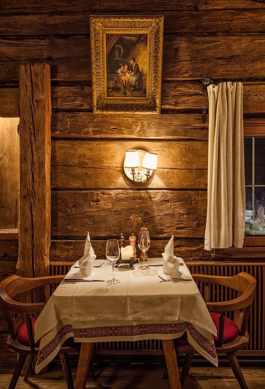 A shot of the interior of the rustic Gasthof Stanglwirt, showcasing a table for two.