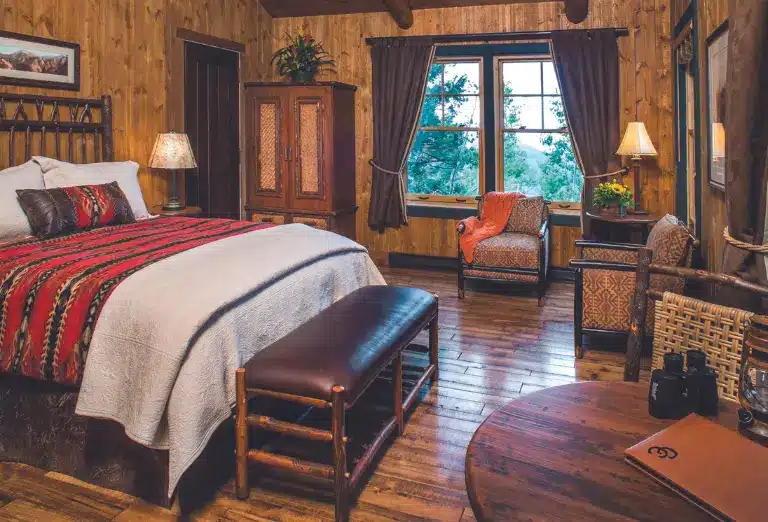 Cozy bedroom at Cloud Camp with wooden decor and a window view of the forest