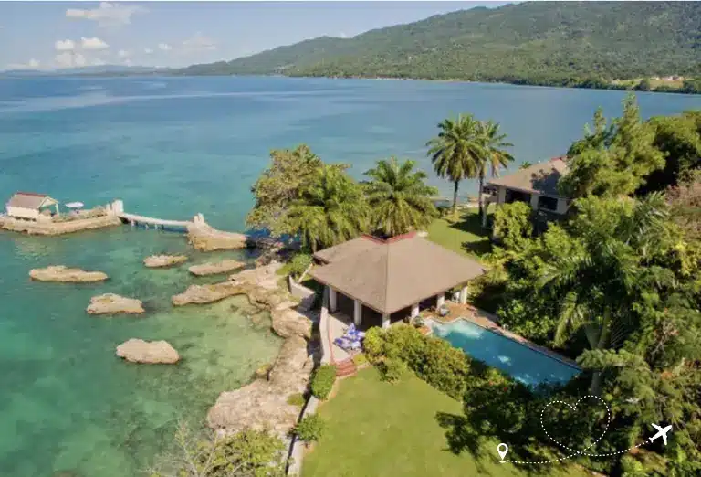 Aerial view of Bluefields Bay Resort in Jamaica, with a private villa overlooking a serene blue bay surrounded by lush greenery