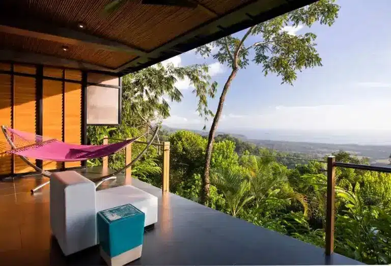 View from a room at the Kura Boutique Hotel in Costa Rica, featuring a hammock on the balcony and a scenic rainforest view.